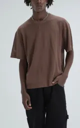 Remera de tejido de punto color café, con mangas cortas y cuello redondo. Presenta una textura calada y un calce ligeramente oversize.