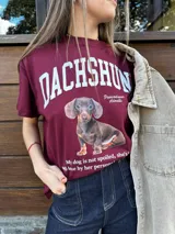 Remera color borgoña con estampa de perro salchicha y texto en blanco.