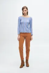 Remera gris de corte ajustado, con cuello redondo y mangas largas. Presenta líneas verticales bordadas en color verde claro y blanco.