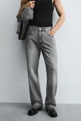 Pantalón de jean celeste de corte flare, con tiro medio, cinco bolsillos, cierre frontal con cremallera y botón, y bajo con acabado irregular.