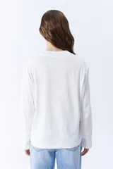 Remera manga larga color crudo con cuello redondo.