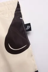 Short de baño con estampado abstracto en blanco y negro, con cintura elástica ajustable, dos bolsillos laterales y uno trasero con cierre, suspensor de malla fina hipoalergénico y protección UV 50.