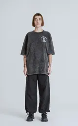 Remera negra con efecto nevado, de corte oversize y manga corta. Estampado en la espalda con diseño de la carta del tarot 'La Torre'.