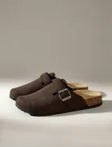 Zuecos marrones con hebilla metálica ajustable y plantilla de corcho.