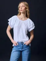 Blusa blanca texturada de poliéster, rayón y elastano, con mangas cortas con volados en capas y aplique de puntilla.