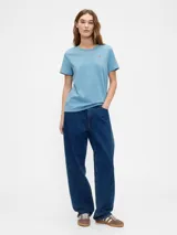 Remera de manga corta color blanco roto (off white) con cuello redondo y un pequeño bordado de un oso en el pecho.