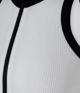 Musculosa blanca sin mangas, con cuello redondo y cierre frontal con cremallera. Presenta detalles contrastantes en negro en cuello y sisas. Diseño seamless.