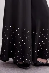 Pantalón amplio de viscosa color negro, con caída fluida, cintura elastizada y lentejuelas en la botamanga.