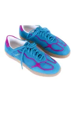 Championes de cuero vacuno color celeste con detalles en fucsia, suela color caramelo y cordones celestes.