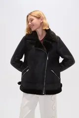 Campera negra de eco cuero con cuello de piel sintética, cierre cruzado con cremallera y bolsillos laterales con cremallera.