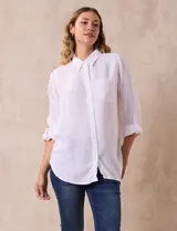 Camisa blanca de lino con cuello con solapa, manga larga regulable con presilla y botón, y abertura central con botones.