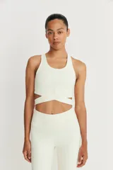 Top deportivo color crudo con tirantes anchos y detalle de tira cruzada en la cintura.