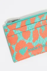 Monedero pequeño con estampado abstracto en tonos naranja y turquesa, con cierre de cremallera y logo metálico de la marca Bimba y Lola.