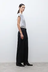 Pantalón negro de vestir, tiro alto, con pinzas frontales y corte ancho y holgado.