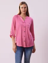 Blusa Ninety texturada color rosado, con cuello a la base, escote en V y abertura central con botones. Delantera con bolsillo y largo de manga regulable con presilla y botón.