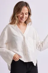 Camisa color crudo con cuello en V y manga larga.