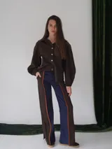 Pantalón de paño combinado con tira de cuero color naranja en los laterales.