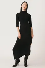 Vestido negro de lana con cuello alto, mangas largas y bajo asimétrico.