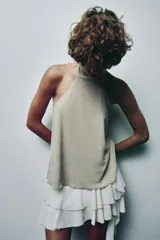 Top de cuello halter color beige, con lazada tipo foulard, forro interior y cierre lateral con cremallera oculta.