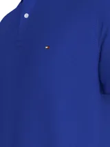 Chomba azul de Tommy Hilfiger, modelo 1985, de corte regular, con cuello tipo chomba, cartera de dos botones, mangas cortas y logo bordado en el pecho.
