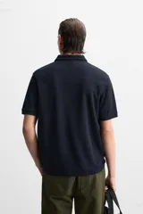Polo verde oliva de tejido piqué, corte regular fit, cuello solapa con cierre frontal de botonadura y manga corta.
