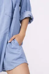 Camisa celeste de mangas largas con puños abotonados, cuello clásico y cierre frontal con botones.