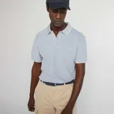 Remera polo celeste de piqué de algodón, corte clásico, con cuello y mangas con ribete blanco.