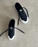 Zapatillas de lona celeste con cordones blancos y suela blanca.