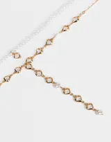 Collar doble con cadena dorada, una con perlas y dije de corazón, y otra con corazones de cristal.
