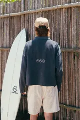 Buzo de tejido de punto gris oscuro con textura acanalada vertical y cuello polo con escote en V. Presenta un estampado grande en blanco con el texto "glassy wa".