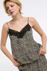 Musculosa con estampado animal print en tonos negro, blanco y verde oliva, con escote en V y detalle de encaje negro en el borde. Tirantes finos ajustables.