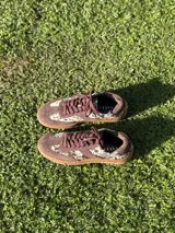 Zapatillas bajas color verde militar de gamuza con suela marrón y detalle trasero en color crema.