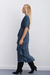 Vestido azul petróleo con escote en V, largo midi, mangas cortas, elástico en la cintura y falda con volados en capas.
