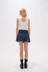 Minifalda negra de jean con diseño acampanado y volantes en el dobladillo.