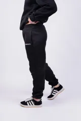 Pantalón de jogging negro con cintura elástica y cordón ajustable. Estampado con la palabra "GRAPHITE" en blanco en la pierna izquierda.