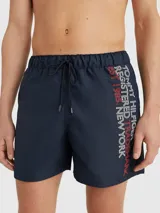 Short de baño azul marino con cintura elástica ajustable con cordón. Estampado vertical con el logo de Tommy Hilfiger en blanco y rojo en la pierna derecha.