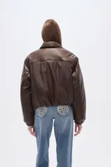 Campera estilo bomber de eco-cuero color marrón oscuro, con cuello camisero, cierre frontal y puños y cintura ajustados.