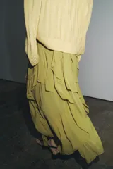 Falda midi color verde oliva, de tiro medio con cintura elástica y volantes asimétricos.