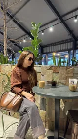 Blusa marrón de muselina de algodón con elástico en el escote, puños y espalda.