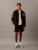 Remera de algodón color beige, de corte regular, cuello redondo y manga corta. Estampado frontal con logo de Calvin Klein en color negro.