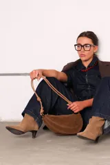 Cartera tipo sobre color bordó, confeccionada en PU tipo gamuza, con correa regulable de nudos chunky y cierre superior.