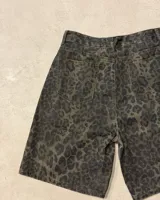 Bermuda de jean tiro alto, corte recto y largo hasta la rodilla, con estampado animal print de leopardo en tonos verde militar y negro.