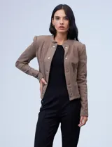 Chaqueta de terciopelo color marrón, con cuello solapa, abertura central con botones y bolsillos delanteros.