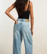 Pantalón baggy de jeans celeste con trabillas en la cintura, cierre tradicional y bolsillos. Corte holgado y de tiro alto.