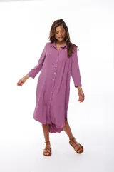 Vestido camisero midi color lila, de corte recto, con cuello camisero, mangas 3/4, cierre frontal con botones y aberturas laterales.