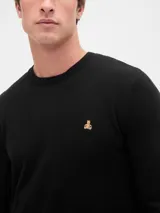 Buzo de tejido de punto color negro, con cuello redondo y un pequeño logo bordado en el pecho.