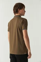Remera polo color ladrillo, de corte recto, con cuello y mangas con terminaciones a contratono en blanco y azul marino. Tiene logo estampado en el pecho.