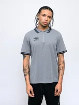 Polo gris con cierre corto, cuello tipo polo y puños con detalles de doble línea negra.
