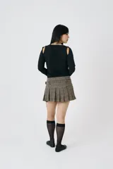 Minifalda plisada con estampado de pata de gallo, cintura caída y cinturón ajustable con detalle de ojales. Confeccionada en mezcla de poliéster y lana suave.