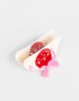 Broche para el pelo color crema con forma de pinza y diseño de frutilla roja con lunares blancos y moño rosa.